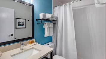 A bathroom with a sink, mirror, and a shower curtain.