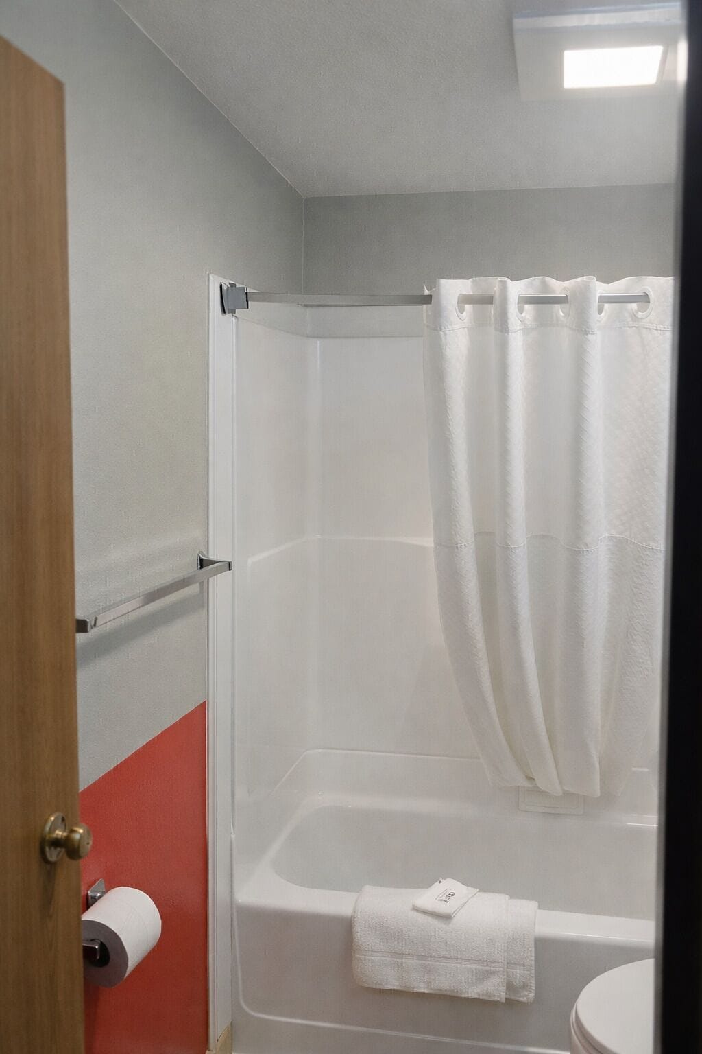 Une salle de bain avec une douche, des toilettes et un porte-serviettes.