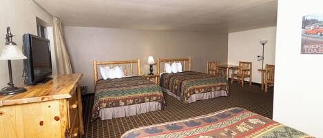 A hotel room with two beds, a wooden dresser, a television, and a chair.