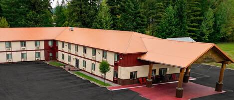 A multi-story building with a parking lot and a covered outdoor area.