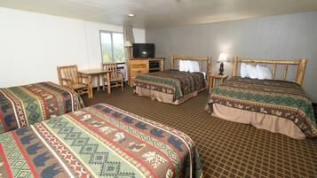 A hotel room with two beds, a TV, a desk, and a chair.
