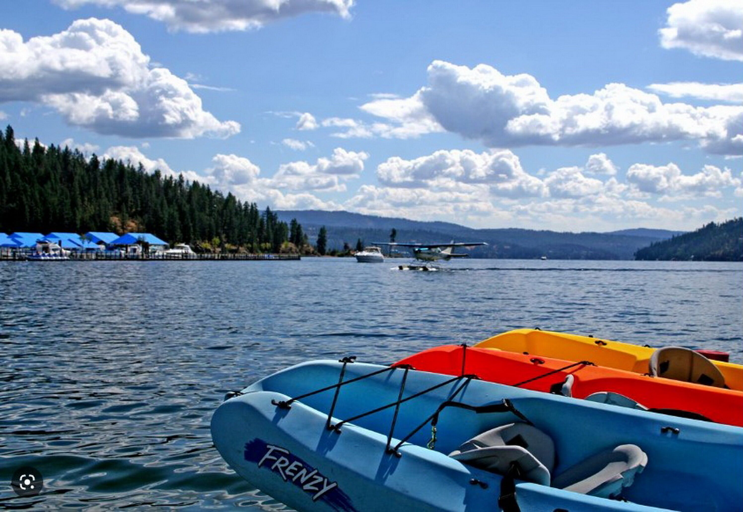 A lake with boats and a small airplane on the water.