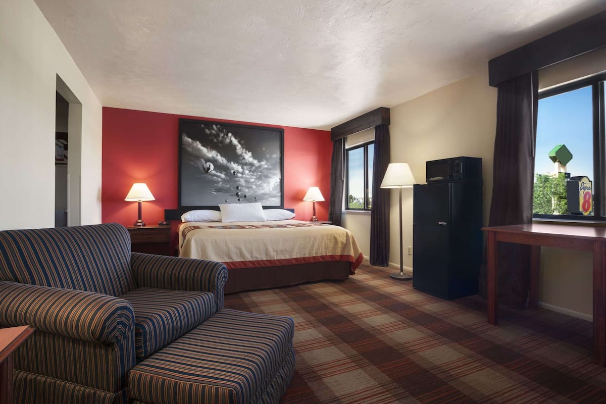 Une chambre d’hôtel équipée d’un lit, d’un canapé, d’un bureau et d’un réfrigérateur.