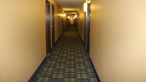 Un pasillo de hotel con suelo a cuadros y puertas a ambos lados.