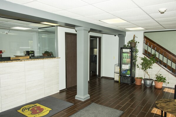 A reception area with a reception desk, a water fountain, and potted plants. - Super 8 by Wyndham Michigan City (Michigan City)