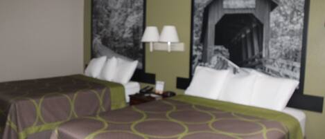 A hotel room with two beds, a nightstand, a lamp, and a wall-mounted TV.