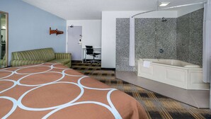 Une chambre d’hôtel comprenant un grand lit, un bureau, une chaise, un espace douche et une salle de bain.