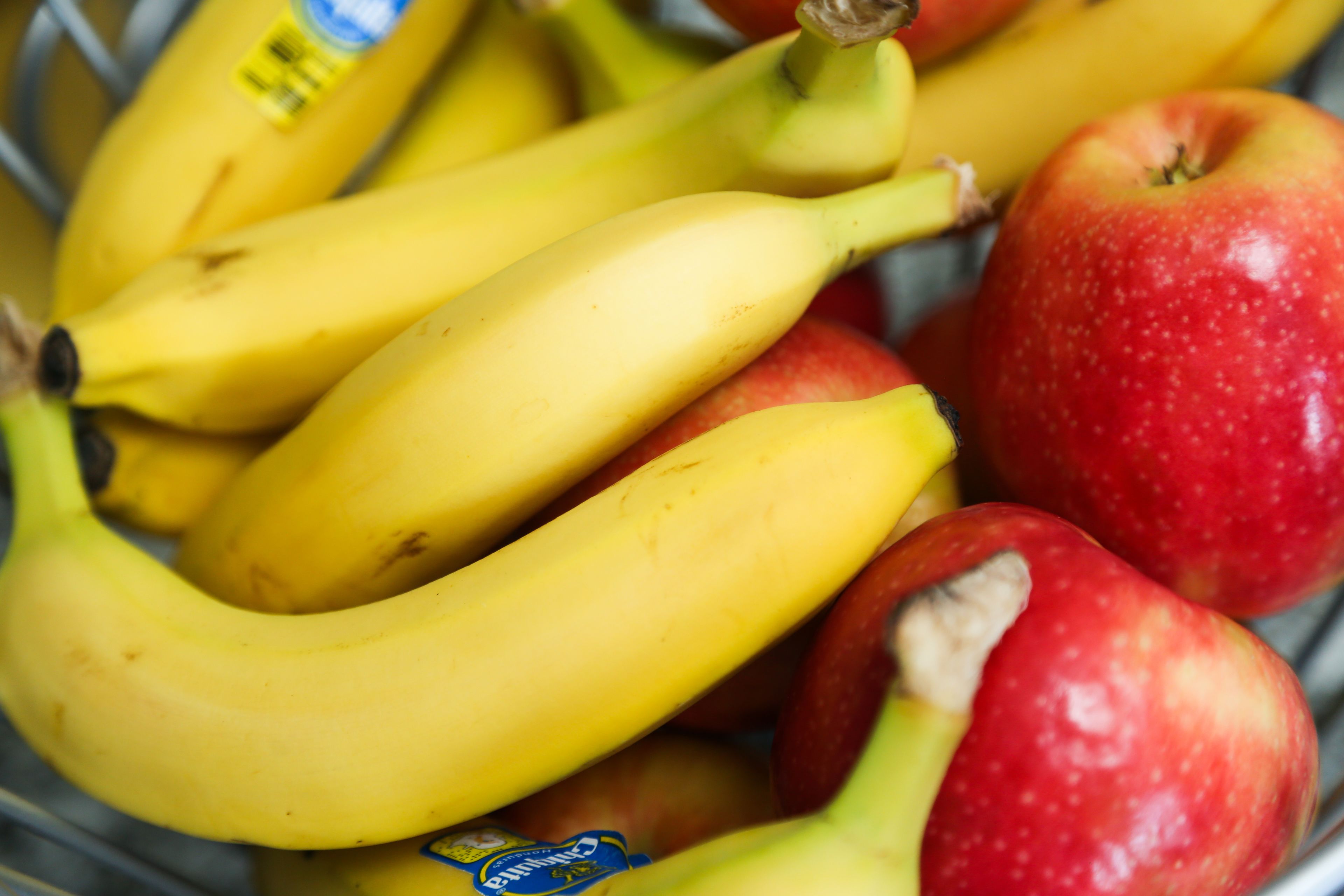 A basket containing bananas and apples.