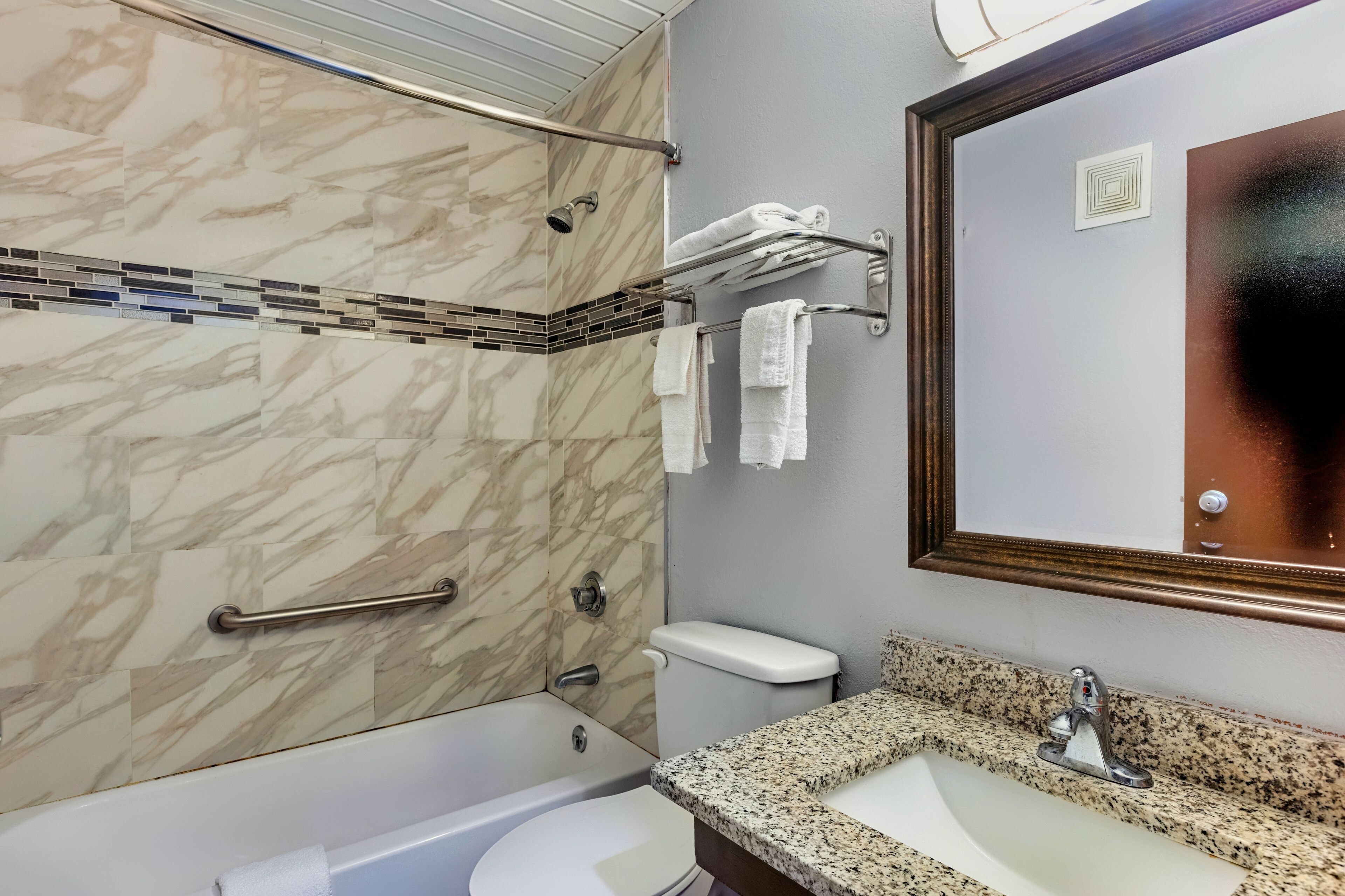 A bathroom with a bathtub, toilet, and sink.