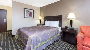A hotel room with a bed, two bedside tables with lamps, a chair, and a door.