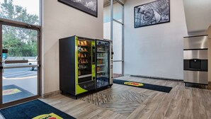 Un hall d’hôtel équipé d’un distributeur automatique, d’un réfrigérateur et d’une grande fenêtre.