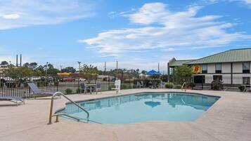 Una piscina al aire libre de temporada, sillones reclinables de piscina