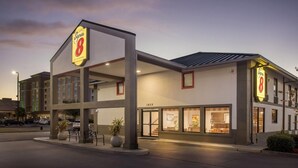 Un hotel Super 8 de diseño moderno, con un llamativo letrero de 'Super 8', ventanas grandes y una entrada bien iluminada.