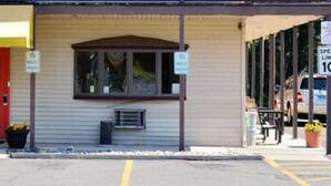 A building with a registration area, a speed limit sign of 10, and a 15-minute parking sign. - Enfield Inn (Enfield)
