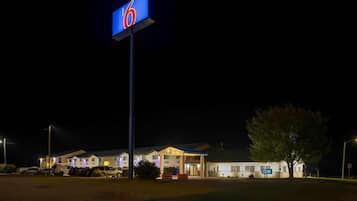 A motel with a prominent '6' sign, multiple buildings, and a parking area.