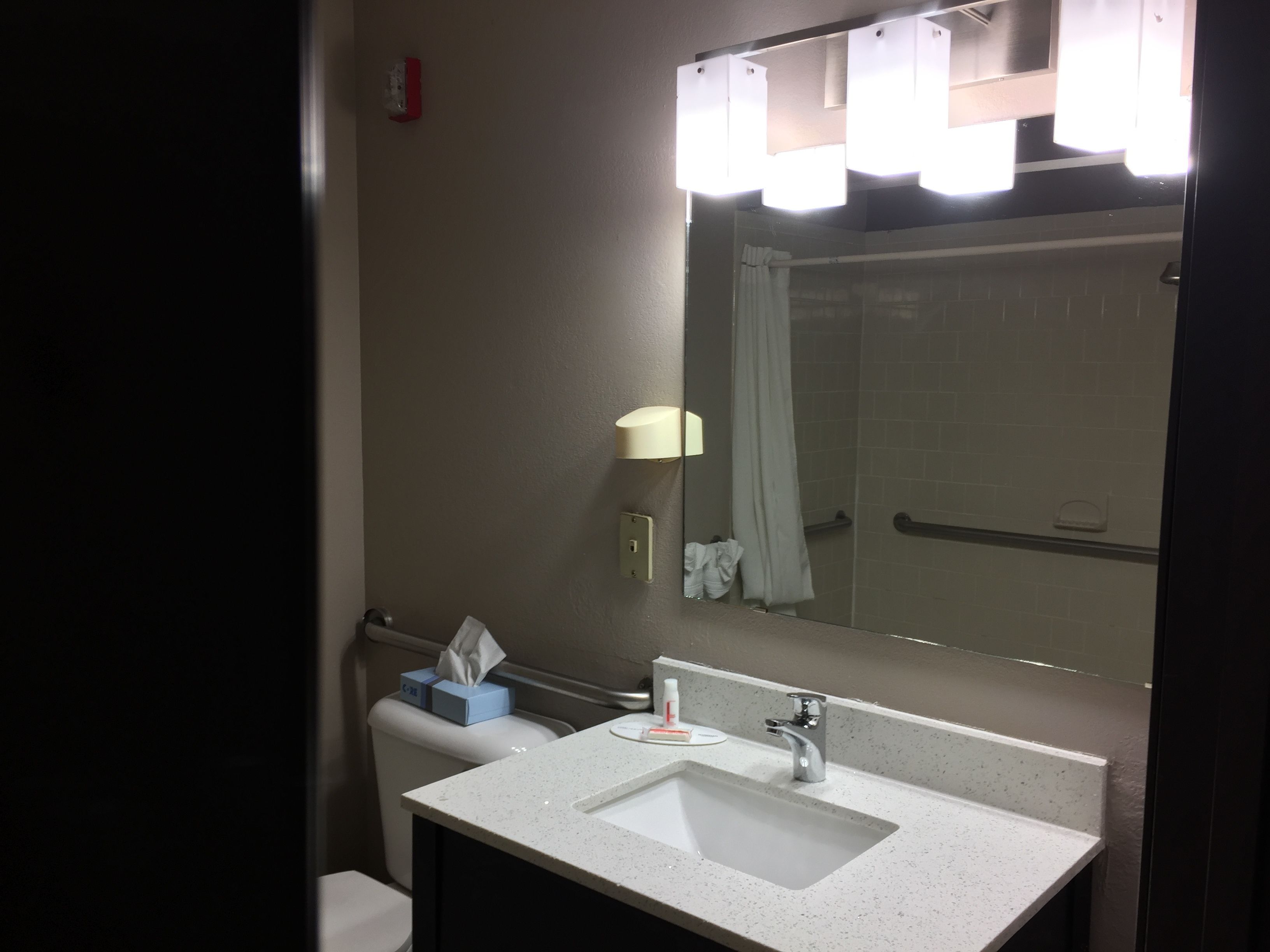 Un baño con lavamanos, espejo y cabina de ducha.