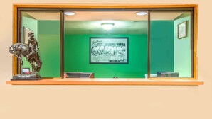 A reception area with a green wall, a framed welcome sign, and a statue of a cowboy on a horse. - Super 8 by Wyndham Buena Vista (Buena Vista)