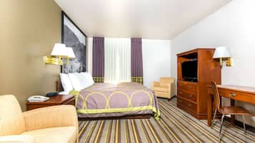 Une chambre d’hôtel comprenant un lit, un bureau, une chaise, une télévision et une table de chevet.
