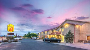A Super 8 motel with a parking lot, several cars parked, and a clear sky with clouds. - Super 8 by Wyndham Buena Vista (Buena Vista)