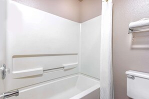 Une salle de bain avec une baignoire blanche, des toilettes et un porte-serviettes.