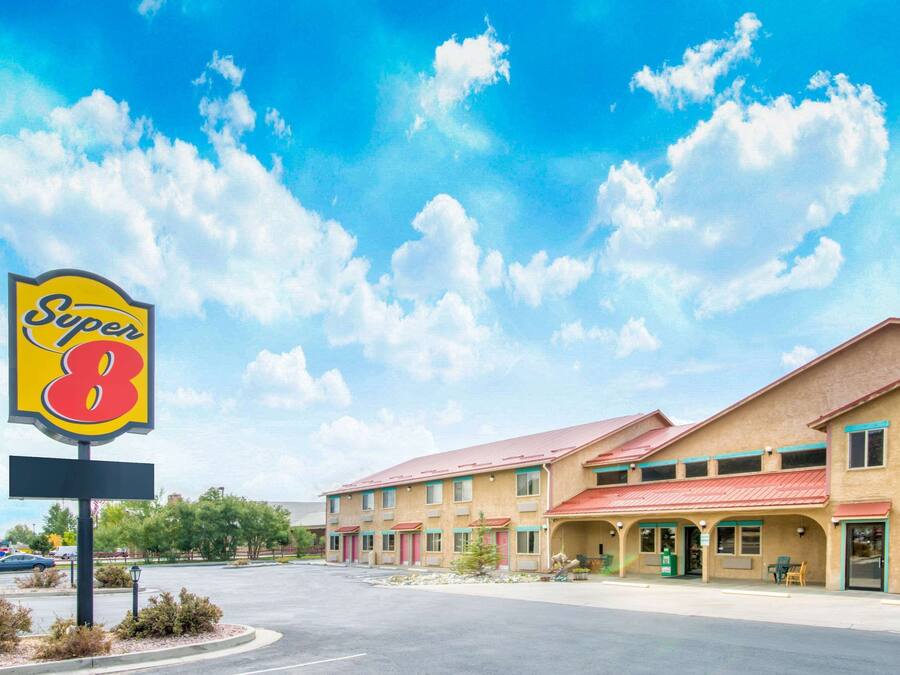 A Super 8 motel with a red roof, multiple rooms, and a parking lot.