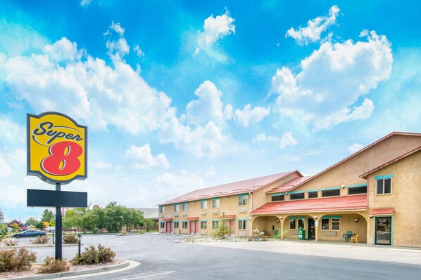Un motel de type Super 8, avec un toit rouge, plusieurs chambres et un parking.