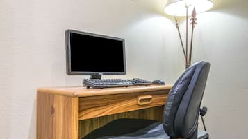 A wooden desk with a Dell monitor, keyboard, and mouse.