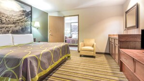 A hotel room with a bed, a chair, a dresser, and a large window. - Super 8 by Wyndham Buena Vista (Buena Vista)