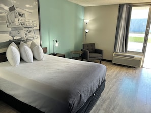 A hotel room with a bed, a chair, a lamp, and a window. - Super 8 by Wyndham Ocala I-75 (Ocala)