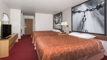 Habitación de hotel con dos camas, televisor, escritorio y un cuadro grande en la pared.