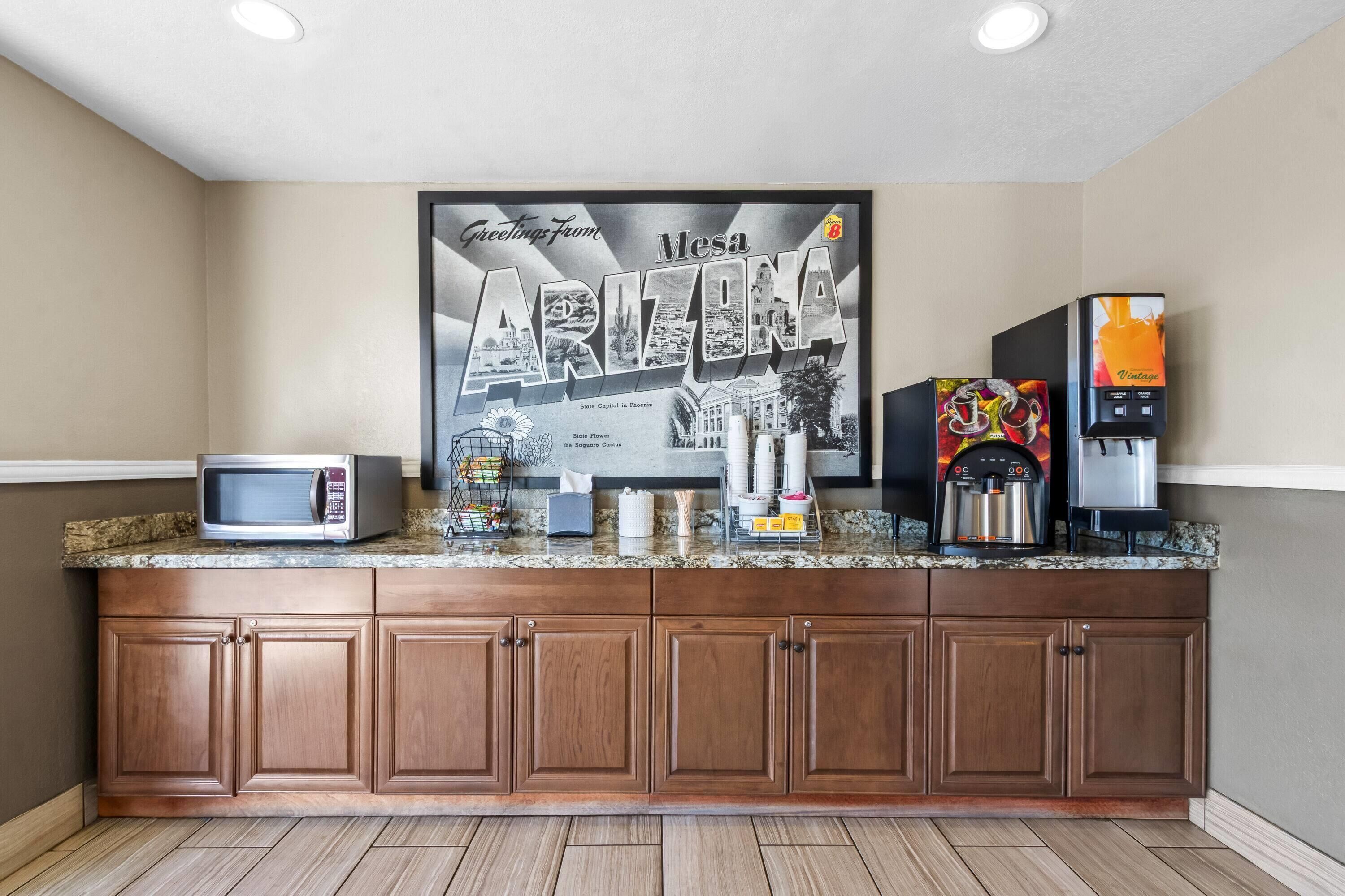 Une cuisine équipée d’un four à micro-ondes, d’une machine à café et d’une grande affiche sur le thème de l’Arizona.