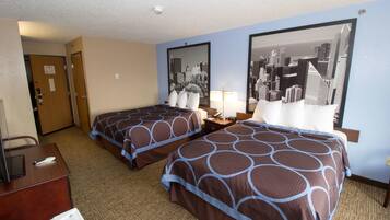 A hotel room with two beds, a desk, and a chair. There is a cityscape painting on the wall.