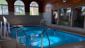 An indoor swimming pool with wooden walls, clear glass windows, and a lifeguard chair. - Super 8 by Wyndham Chicago O'Hare Airport (Elk Grove Village)