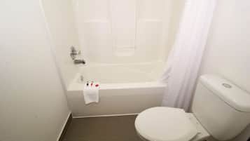A bathroom with a bathtub, toilet, and a shower curtain.