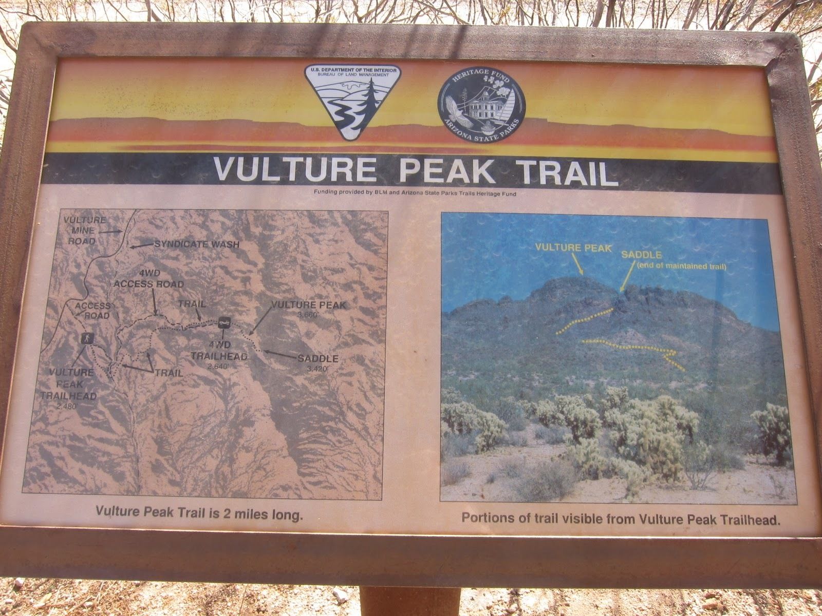 A sign for Vulture Peak Trail with a map and a photo of the trailhead.