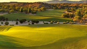 Golfkenttä, jossa on useita lyöntialueita, hiekkabunkkereita ja lippusalko.