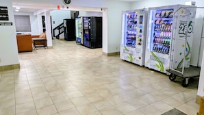 A hotel corridor with vending machines, a guest laundry and ice machine, and a clock on the wall. - Americas Best Value Inn Apache Junction (Apache Junction)