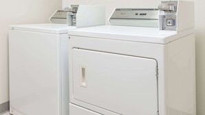 Two white stacked washer and dryer units in a laundry room.