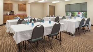 A conference room with multiple tables, chairs, and water bottles.
