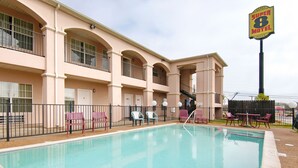 Un hotel con piscina, zona de estar al aire libre y un cartel que dice 'Super 8 Motel'.