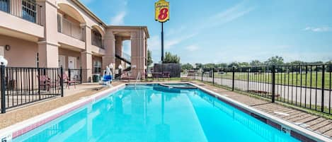 Una piscina al aire libre de temporada, sillones reclinables de piscina