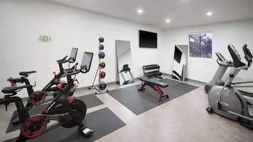 A gym with stationary bikes, a treadmill, and weight machines.