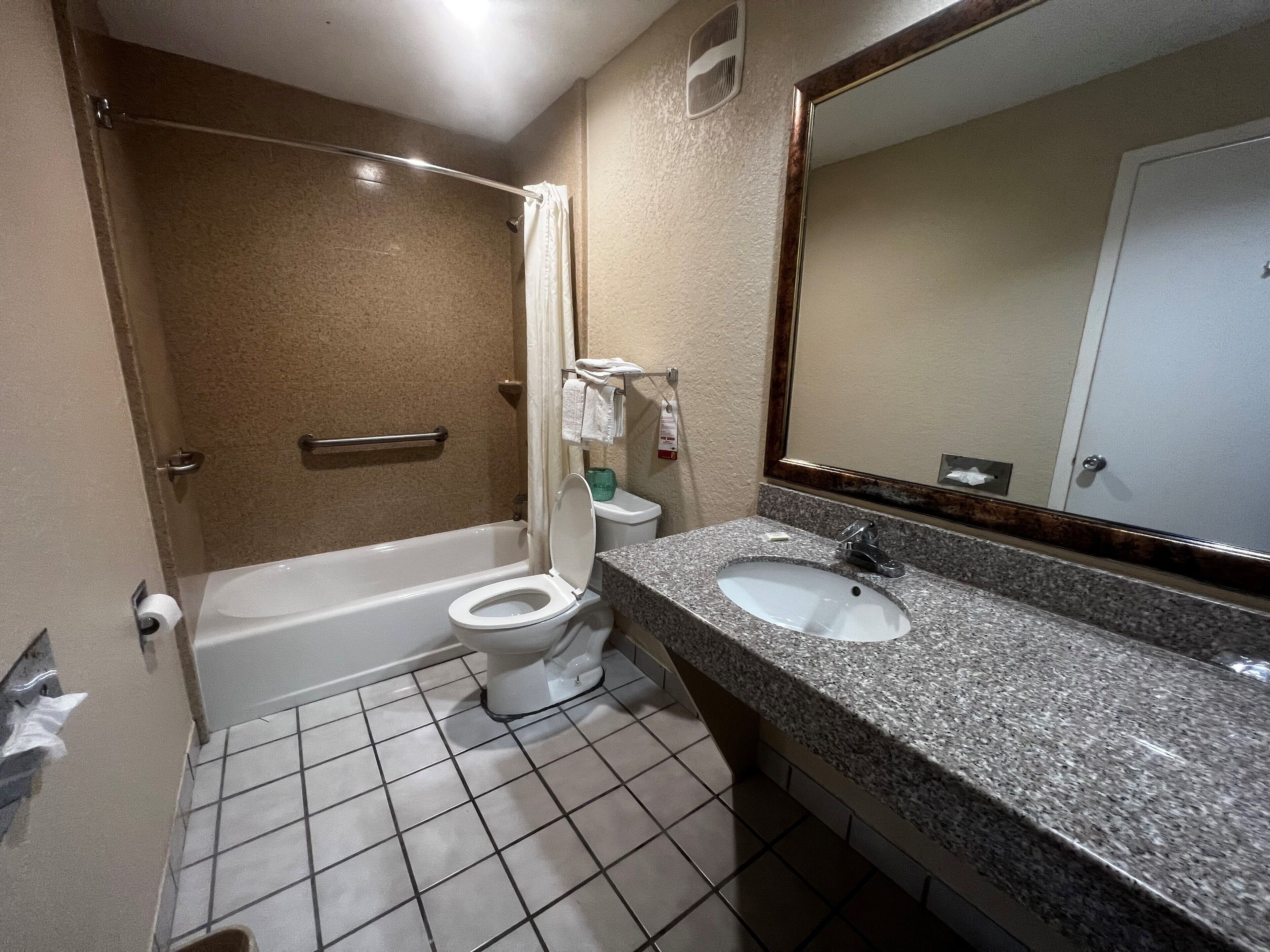Un baño con bañera, inodoro y lavamanos.