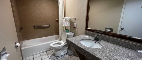 Un baño con bañera, inodoro y lavamanos.