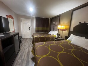 Cozy retreat with a bed, bedside table, desk, and television.