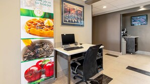 Una zona de recepción con escritorio, ordenador y carteles en la pared.