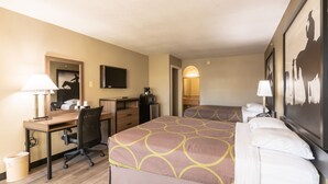 Een hotelkamer met een bed, bureau, stoel en televisie.