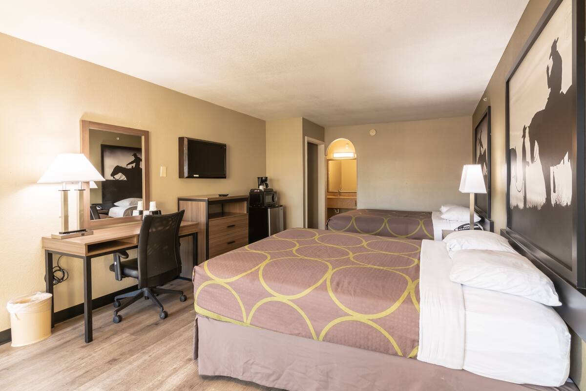 Une chambre d’hôtel équipée d’un lit, d’un bureau, d’une chaise et d’un téléviseur.