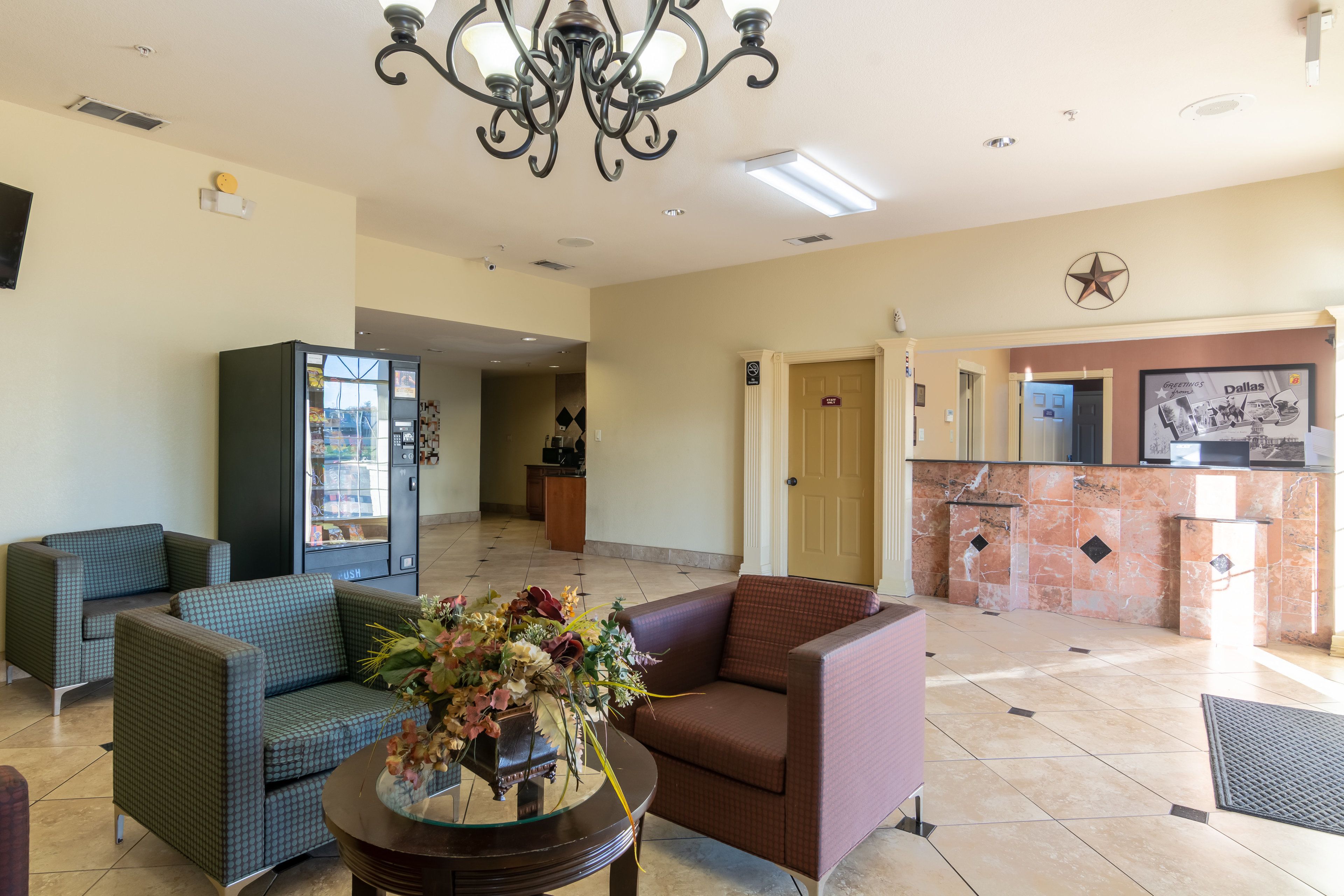 A lobby with seating, a reception desk, and a chandelier.