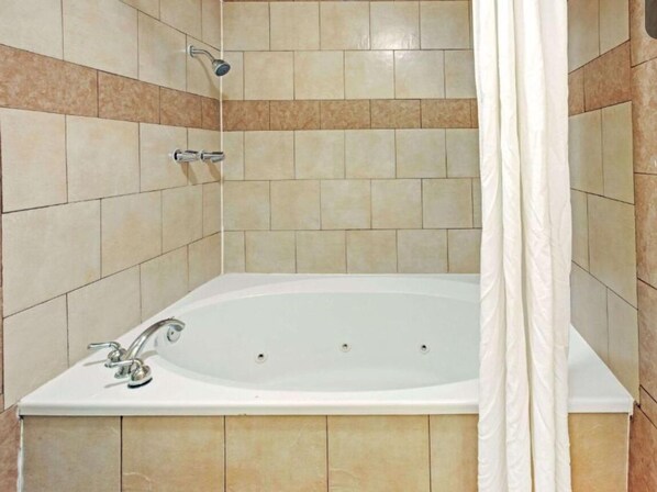 Een bad/douchecombinatie, een haardroger, handdoeken